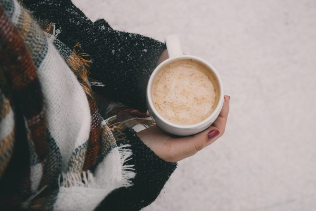 Woman outside in the snow with a hot beverage
